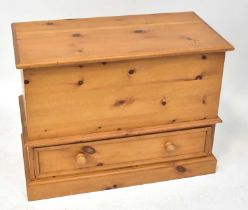 A modern waxed pine blanket box with lift-up top above a cupboard drawer, on a plinth base, 69 x