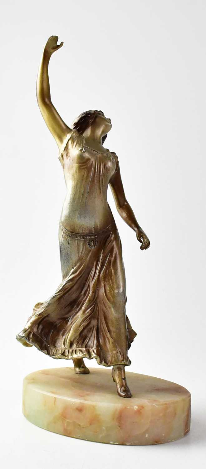 A painted bronze sculpture of a female dancer, raised on an oval hardstone plinth, unsigned,