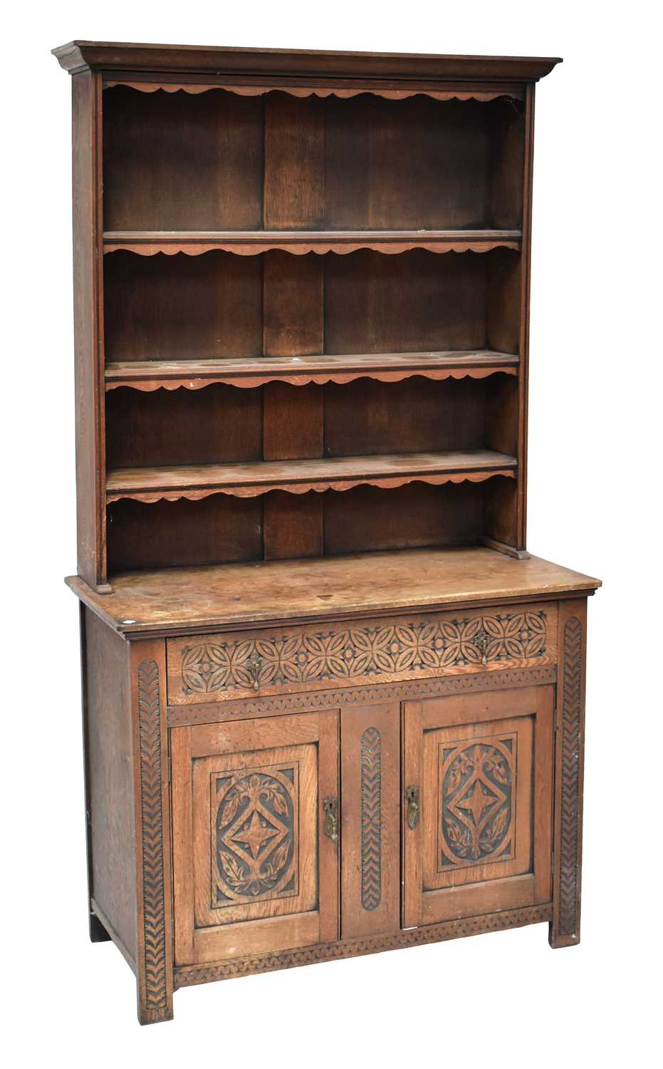 An early 20th century carved oak dresser with enclosed plate rack of three shelves, above a base