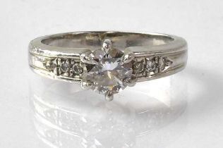 A platinum ring with claw set diamond, approx. 0.75ct, and three small diamonds to each shoulder,