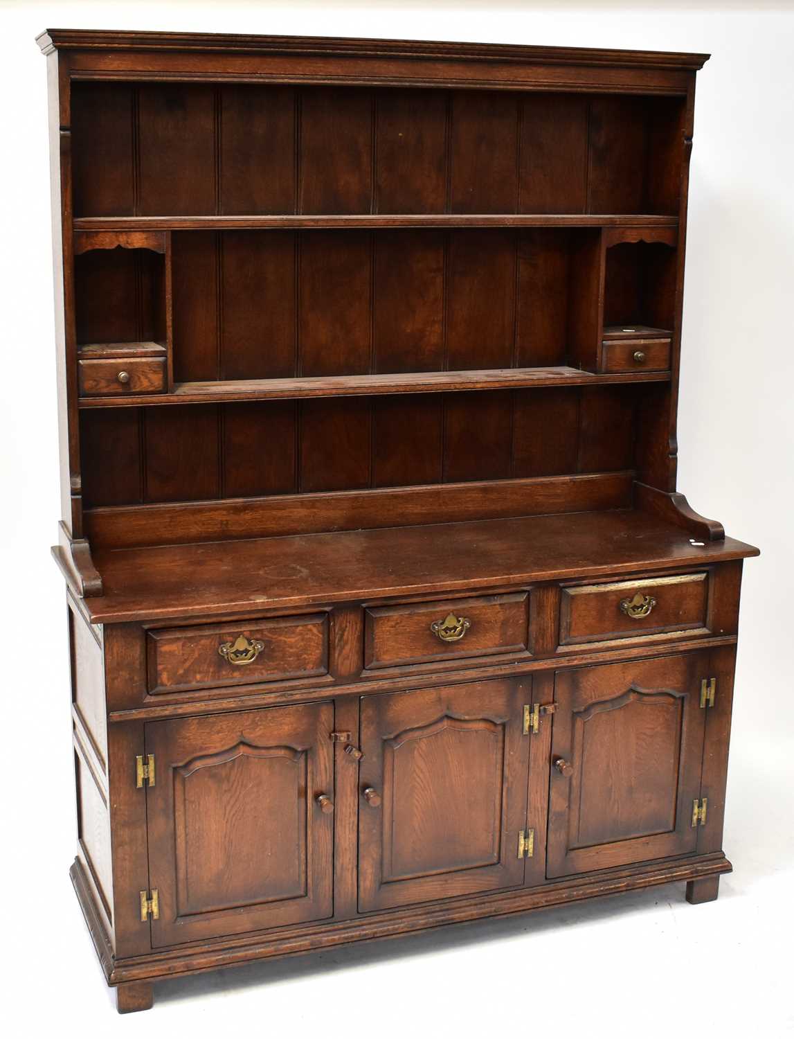 A Georgian-style oak dresser with boarded plate rack incorporating two spice shelves, above a base