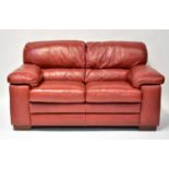 A modern red leather two-seater sofa with stitched detail, 92 x 165 x 96cm.