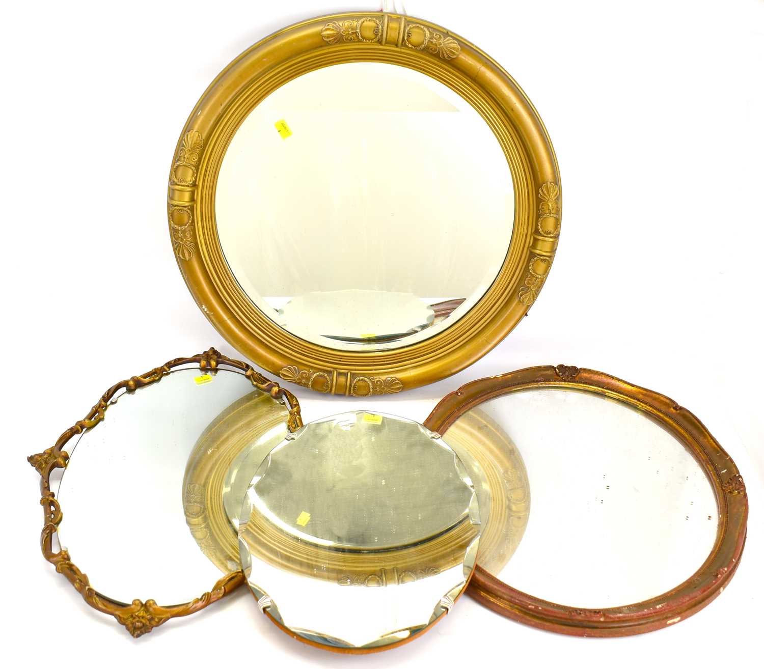 Four wall mirrors, comprising an oval example with bevelled edge, length 45cm, a circular mirror