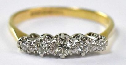 An 18ct gold ring set with five white gold claw set graduated diamonds, stamped '18', size P,