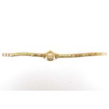 ACCURIST; a ladies' 9ct gold wristwatch, the silvered dial set with Arabic and baton numerals,