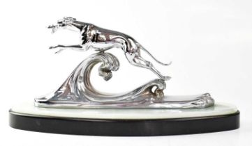 A chrome plated greyhound figure group depicting a greyhound in full stride above a wave, raised