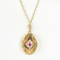 A 9ct gold oval double locket set with central ruby and diamond, on a 9ct gold belcher link chain,