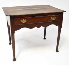 A Georgian oak lowboy with shaped top above a single frieze drawer and shaped apron, raised on
