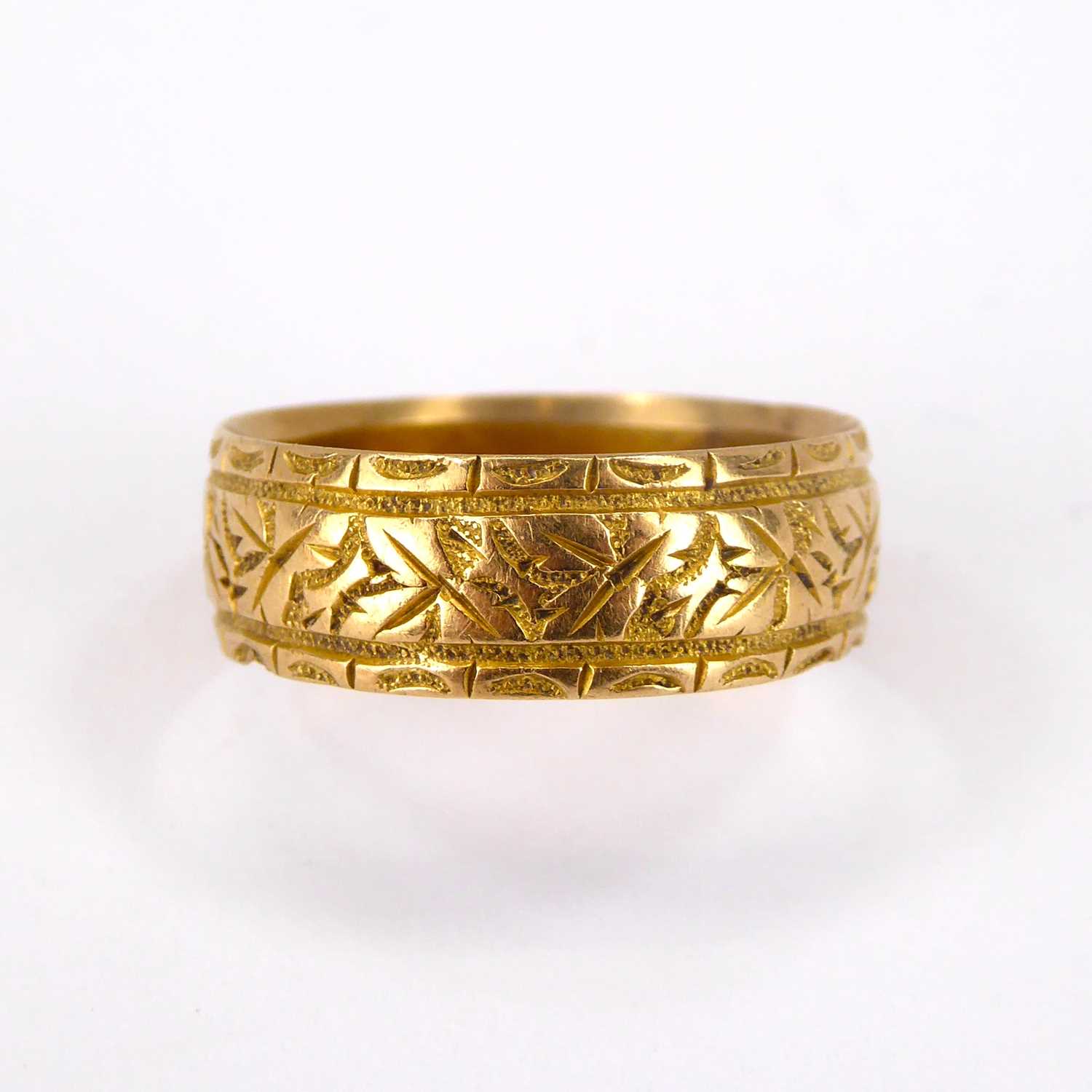 An 18ct gold band ring with textured pattern, size Q, approx. 4.2g.