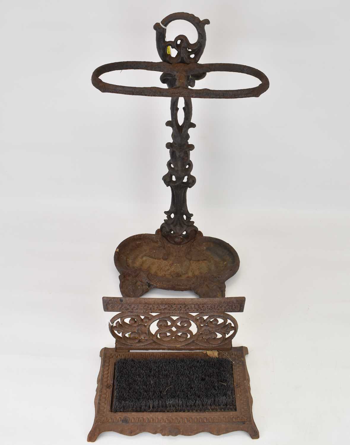 A cast iron stick stand with double hoop top, pierced floral column and lilypad-style drip tray