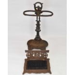 A cast iron stick stand with double hoop top, pierced floral column and lilypad-style drip tray