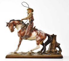 An early 20th century painted spelter figural match striker modelled as a cowboy on horseback,