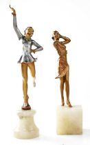 A pair of Art Deco style painted spelter figures of young ladies, raised on hardstone plinths, one