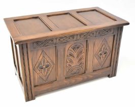 A small reproduction oak chest with panelled front and top to stile supports, 48 x 62 x 43cm.