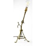 An unusual brass articulated reading lamp with tripod base doubling as a wall mounting hook,