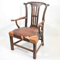 A George III oak armchair with yoke-shaped top rail, pierced back splat, scroll arms, stuffed