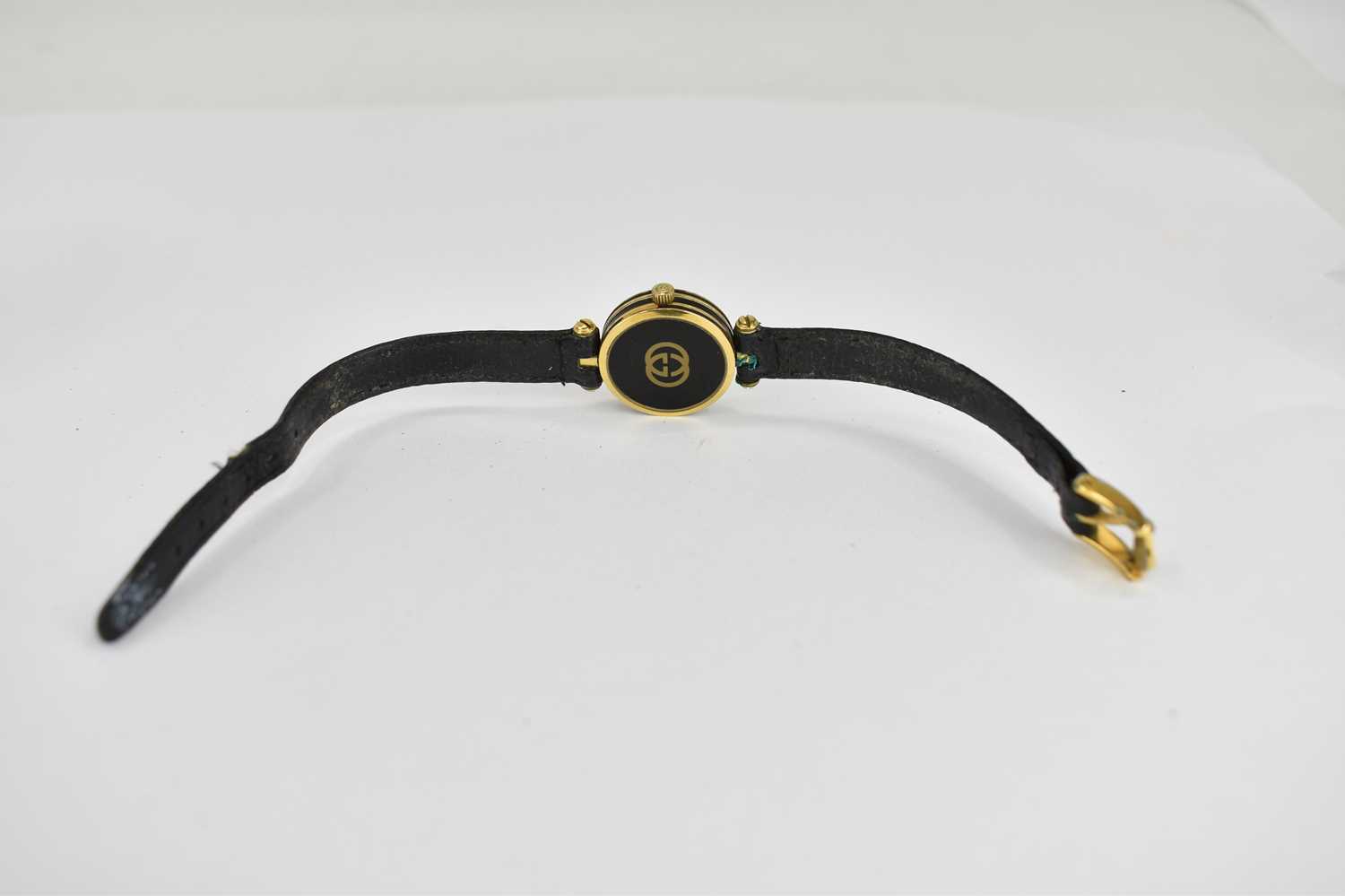 GUCCI; a ladies' dress watch, the black dial with gold hands, on a black strap. - Image 2 of 3