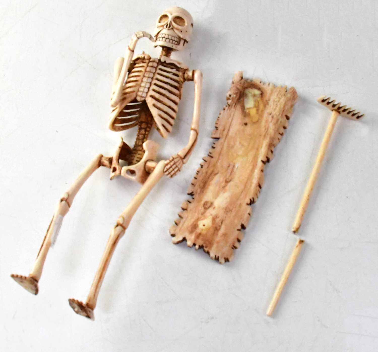 A large carved bone model of a skeleton carrying a rake, height 29cm. - Image 2 of 2