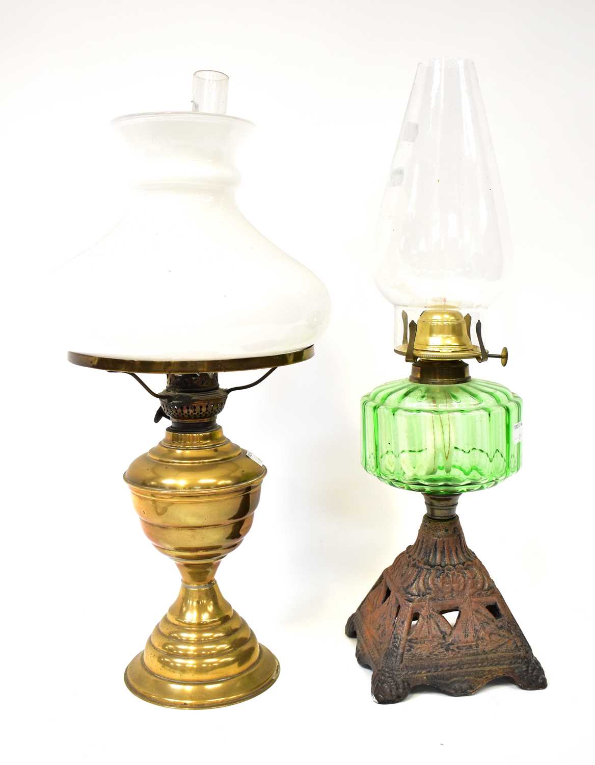 Two vintage oil lamps, comprising a cast metal example with green glass reservoir and a brass