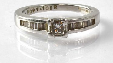 A platinum solitaire diamond ring with square cut central diamond, approx. 0.25ct, flanked with