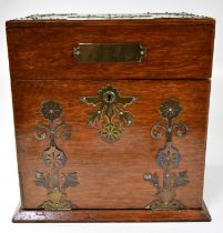 A late Victorian brass mounted oak cased tantalus and games compendium with three fitted glass