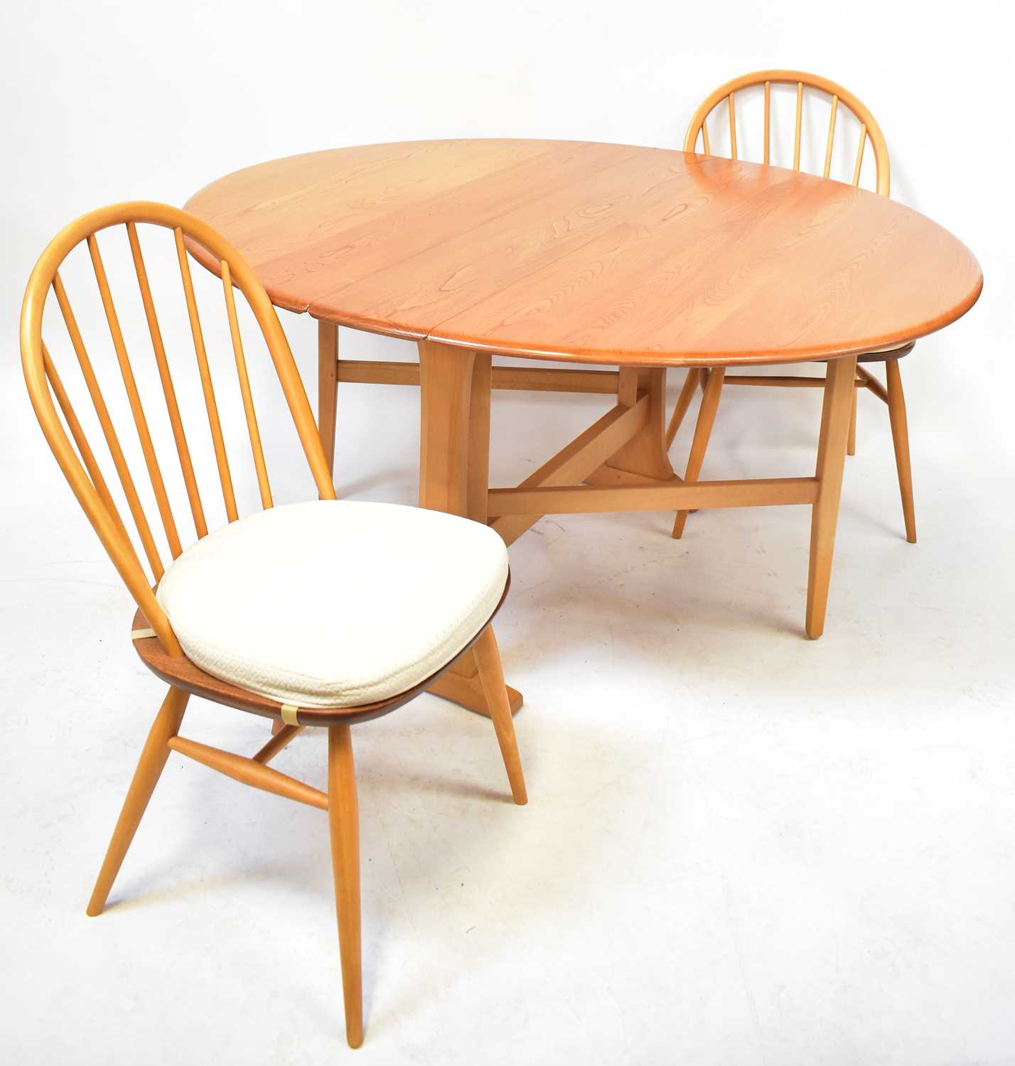 ERCOL; a light elm Windsor gateleg drop-leaf dining table, 72 x 130cm, with four Ercol stick back