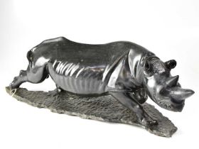 An unusual carved hardstone figure of a rhino on a naturalistic base, with indistinct signature,