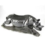 An unusual carved hardstone figure of a rhino on a naturalistic base, with indistinct signature,