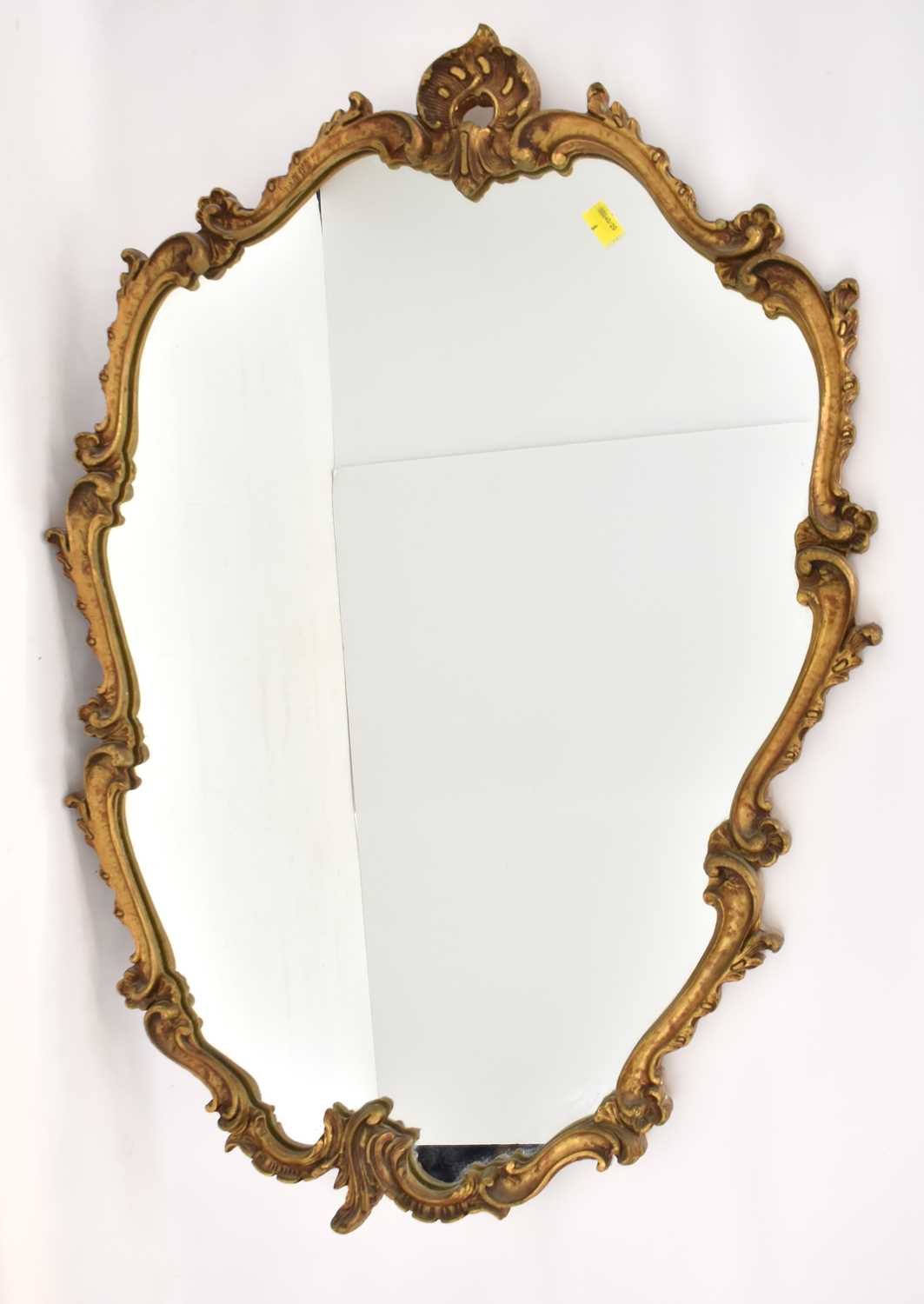 A circa 1950s large Rococo-style wall mirror with shell-shaped top, shield-shaped mirror in a