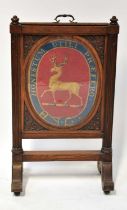 A Victorian oak fire screen with tapestry glazed and sliding insert with crest depicting a stag with