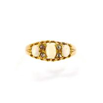 An 18ct gold ring set with three oval white opals, flashing green and red, separated by two rows