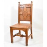 An early 20th century Gothic-style church oak chair, with carved 'IHS' within cross to the back