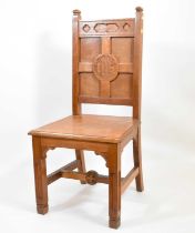 An early 20th century Gothic-style church oak chair, with carved 'IHS' within cross to the back