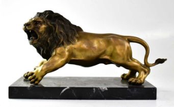 A gilded bronzed figure of a lion, raised on a veined black hardstone base, unsigned, 22 x 36 x