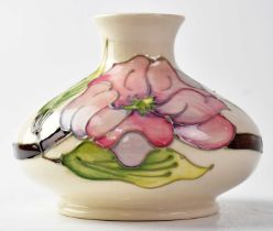 MOORCROFT; a 'Magnolia' pattern squat vase, cream ground with impressed green marks, initialled '