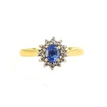 An 18ct gold ring with central claw set sapphire surrounded by tiny diamonds, size P, approx. 3.