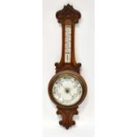 An early 20th century carved oak banjo aneroid barometer with enamelled dial and thermometer, height