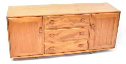 ERCOL; a light elm Windsor sideboard, with three drawers flanked by a pair of cupboard doors, 69 x