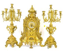 A German brass three-piece clock garniture of Classical form, decorated with shells and oak
