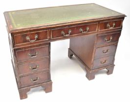 A Georgian-style mahogany twin-pedestal desk, each pedestal with three drawers, with green leather