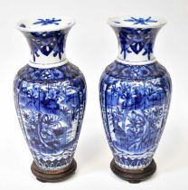 A pair of early 20th century Japanese blue and white baluster vases on hardwood stands, height 40.