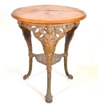 An early 20th century Britannia pub table with circular wooden top, three cast iron supports to claw