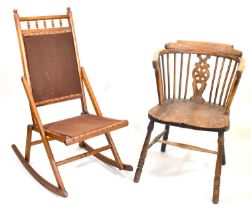 A 19th century elm Windsor chair with stick back, bull's eye back splat, shaped arms, one-piece seat