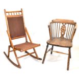 A 19th century elm Windsor chair with stick back, bull's eye back splat, shaped arms, one-piece seat