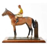 An early 20th century painted spelter figural match striker modelled as a horse and jockey next to a