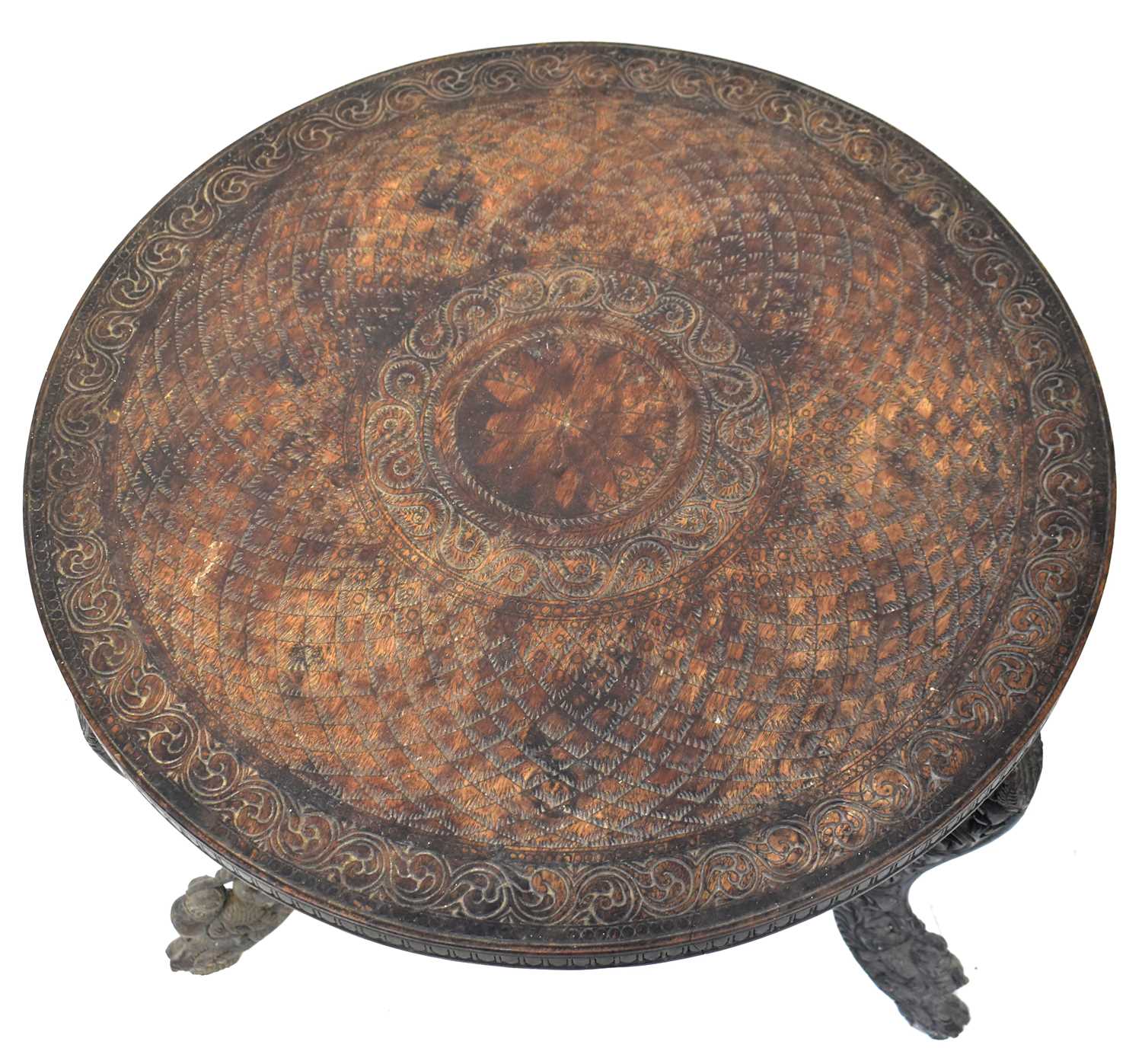 An Indian carved wooden circular topped side table, raised on three scroll feet with carved - Image 2 of 2