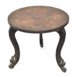 An Indian carved wooden circular topped side table, raised on three scroll feet with carved