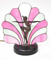 An Art Deco style table lamp in the form of a bronzed spelter female dancer in front of a pink and