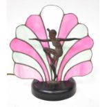 An Art Deco style table lamp in the form of a bronzed spelter female dancer in front of a pink and