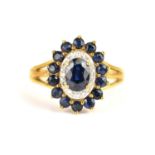 A 9ct gold cluster ring claw set with central sapphire surrounded by tiny diamond chips, in